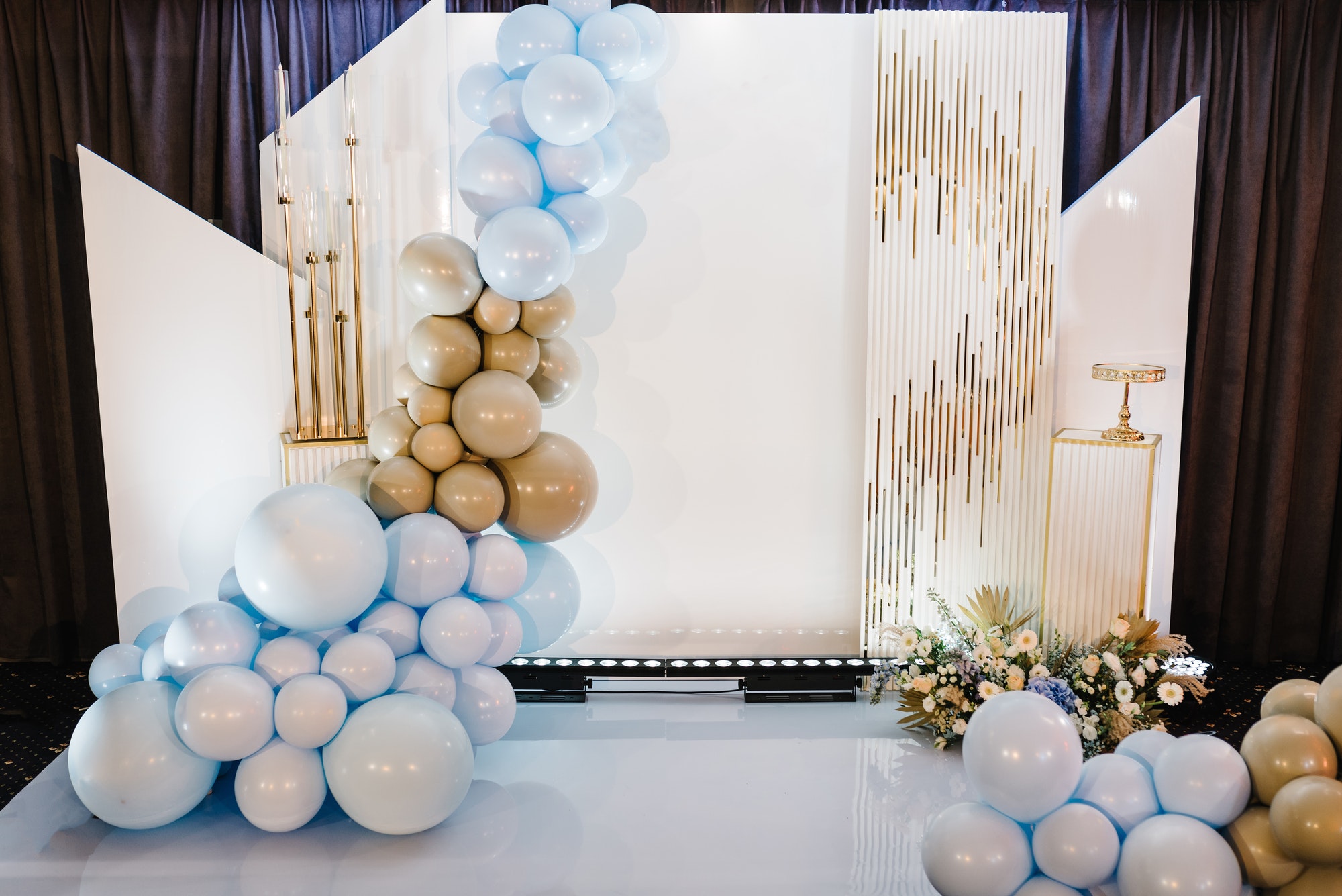 Arch decorated candles and brown, gold, and blue balloons for the wedding ceremony. Celebration